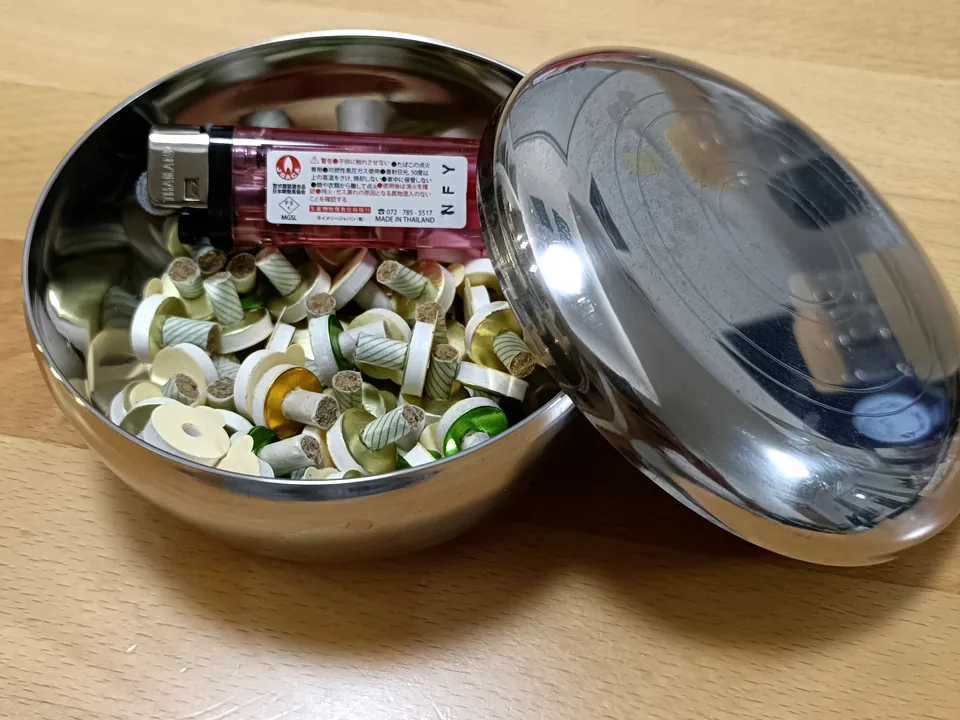 金属のケースに、台座灸とライターを入れているところ