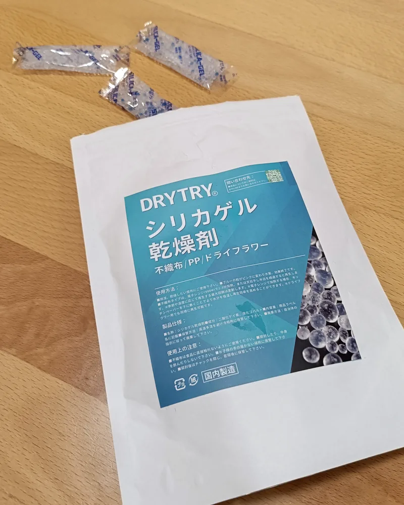 市販のシリカゲル乾燥剤の袋と、小分けの乾燥剤